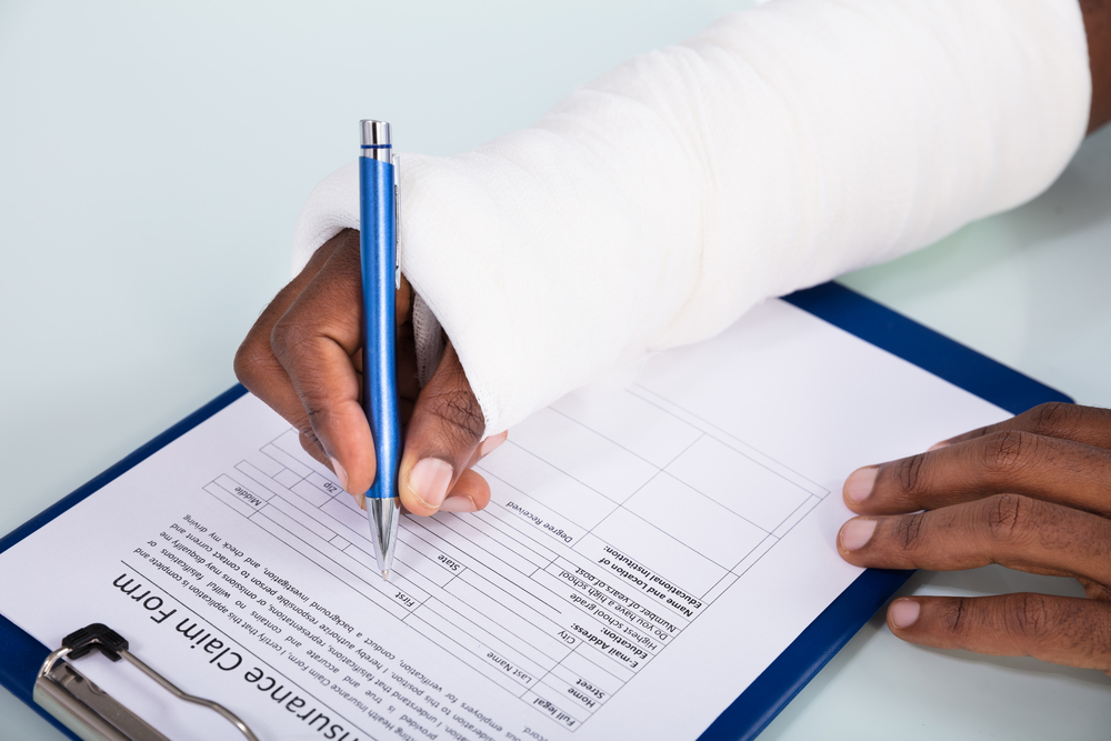 Workers’ Comp for Construction Accidents - Injured Man Filling Insurance Claim Form